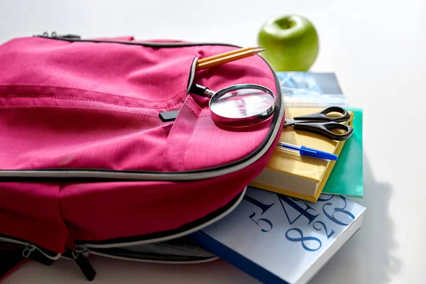 Hátizsák könyvekkel, iskolai felszereléssel és almával — Stock Fotó