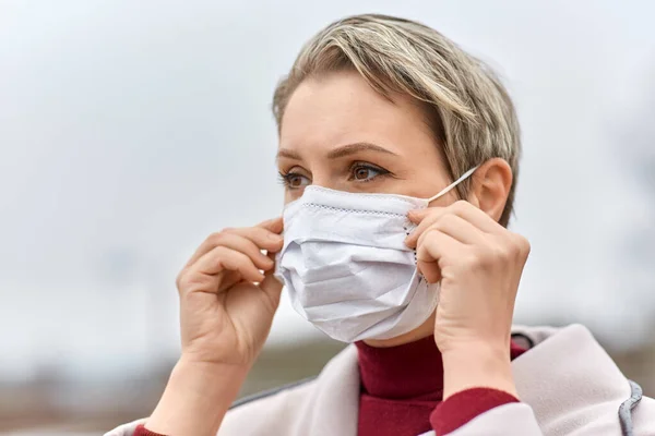 Jovem mulher usando máscara médica protetora — Fotografia de Stock