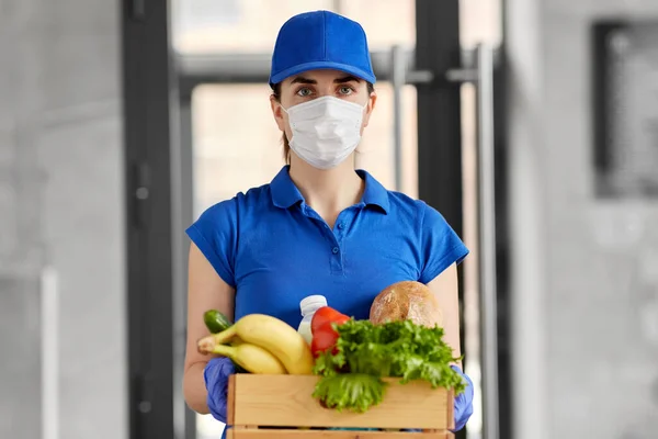 Mujer de entrega en mascarilla con comida en caja — Foto de Stock