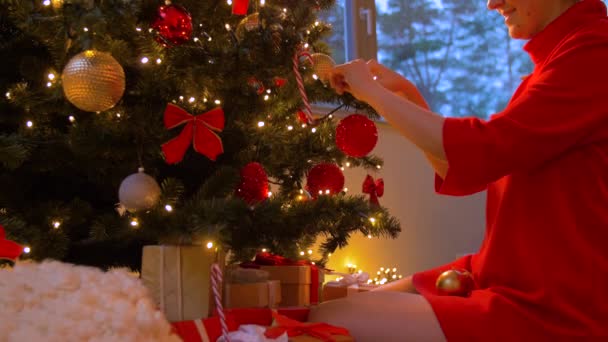 Mujer decorando árbol de navidad con bola — Vídeo de stock