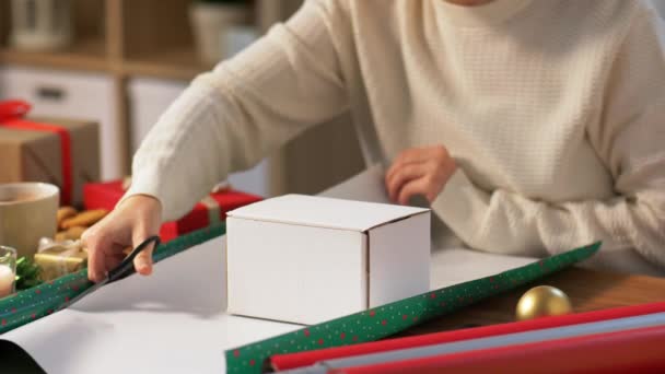 Hände wickeln Weihnachtsgeschenk zu Hause in Papier — Stockvideo