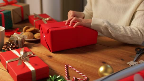 Mujer envolviendo el regalo de Navidad en papel en casa — Vídeos de Stock