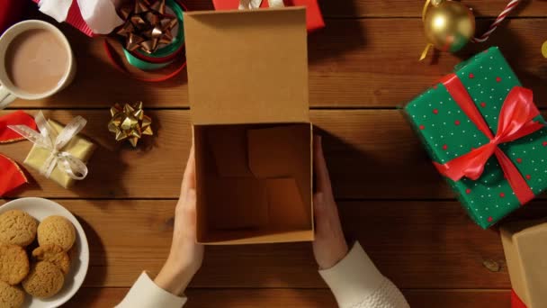 Mujer cerrando regalo de Navidad vacío en mesa de madera — Vídeos de Stock