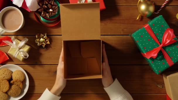 Woman closing empty christmas gift on wooden table — Stock Video