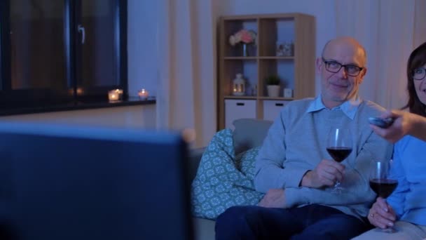 Feliz casal sênior beber vinho tinto e assistir tv — Vídeo de Stock