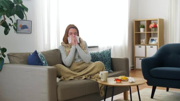 Mujer enferma que sopla la nariz en papel en casa — Vídeos de Stock