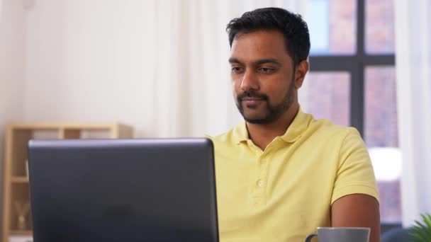 Man met laptop het drinken van koffie thuis kantoor — Stockvideo