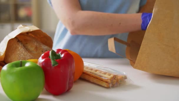 Mujer en guantes tomando comida de la bolsa de papel en casa — Vídeos de Stock