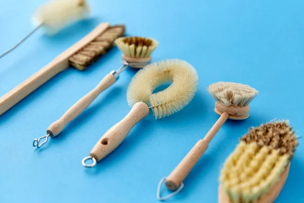 Different cleaning brushes on blue background — Stock Photo, Image