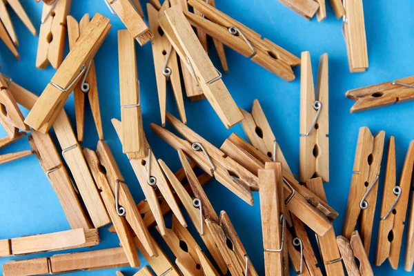 Close up of wooden clothespins on blue background — Stock Photo, Image