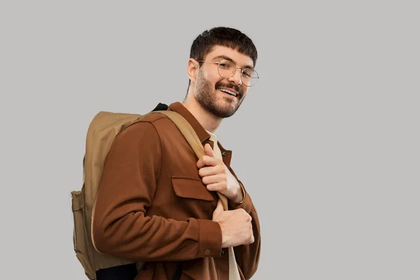 Усміхнений молодий чоловік в окулярах з рюкзаком — стокове фото
