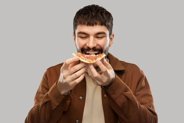 Glad leende ung man äter pizza — Stockfoto