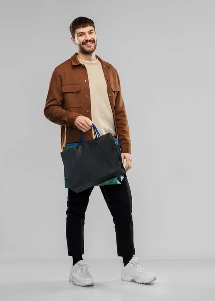 Feliz joven sonriente con bolsas de compras —  Fotos de Stock