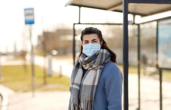 Wanita muda mengenakan masker medis di halte bus — Stok Foto