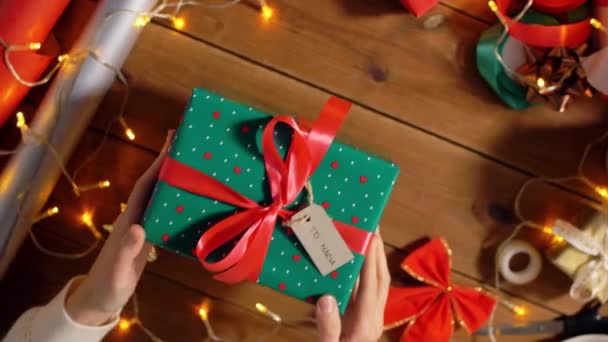 Mani in possesso di regalo di Natale con etichetta del nome — Video Stock