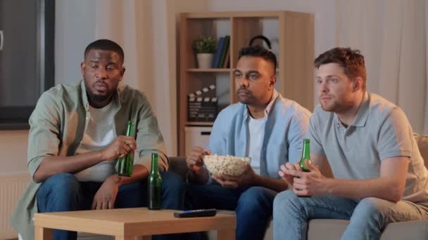 Amis masculins avec bière regarder la télévision à la maison — Video