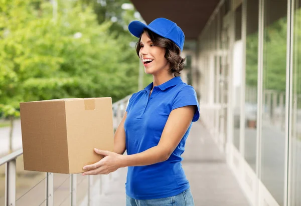 Chica entrega feliz con caja de paquete en azul — Foto de Stock