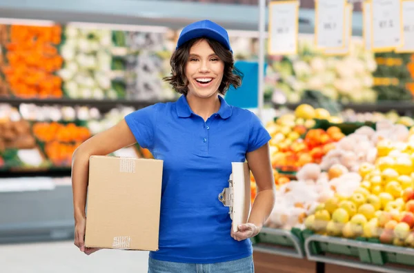 Chica entrega feliz con caja en la tienda de comestibles —  Fotos de Stock