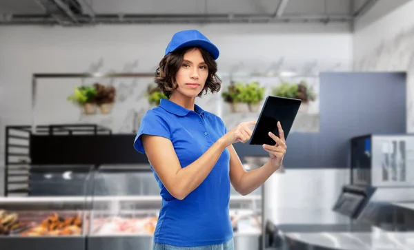 Delivery girl in uniform with tablet pc at store — Stock Photo, Image
