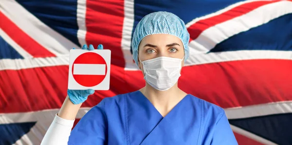 戴口罩的英国医生或护士有停车标志 — 图库照片