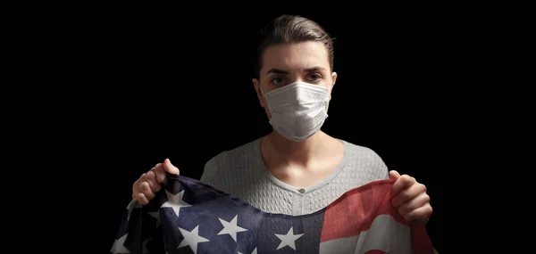 Хвора жінка в масці для обличчя тримає прапор Америки — стокове фото