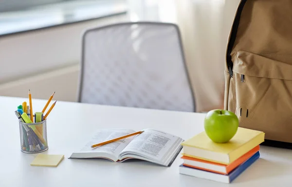 Libros, manzanas y útiles escolares en la mesa en casa — Foto de Stock