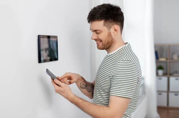 Uomo sorridente utilizzando tablet computer a casa intelligente — Foto Stock