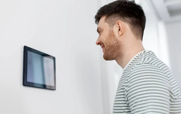 Hombre feliz mirando el ordenador tableta en el hogar inteligente —  Fotos de Stock