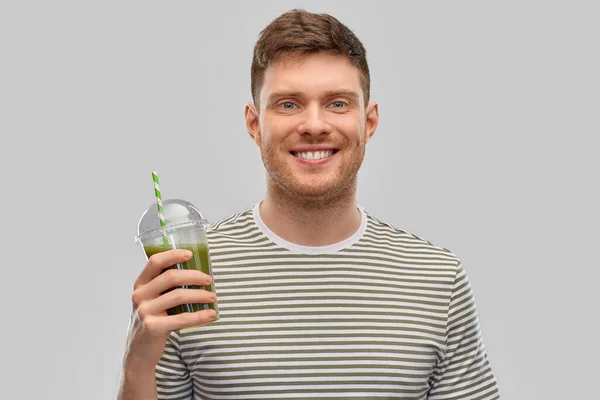 Man die groene smoothie drinkt uit wegwerpbeker — Stockfoto