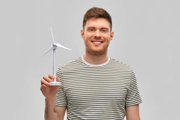 Giovane uomo sorridente con turbina eolica giocattolo — Foto Stock
