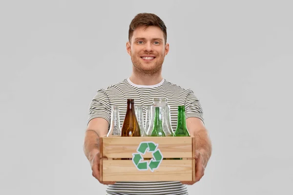 Sorridente giovane uomo selezionando rifiuti di vetro — Foto Stock