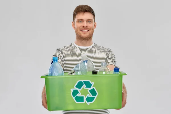 Lächelnder junger Mann beim Sortieren von Plastikmüll — Stockfoto