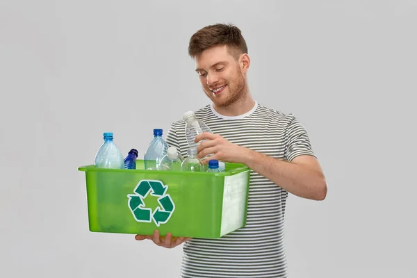 Sonriente joven clasificación de residuos de plástico — Foto de Stock