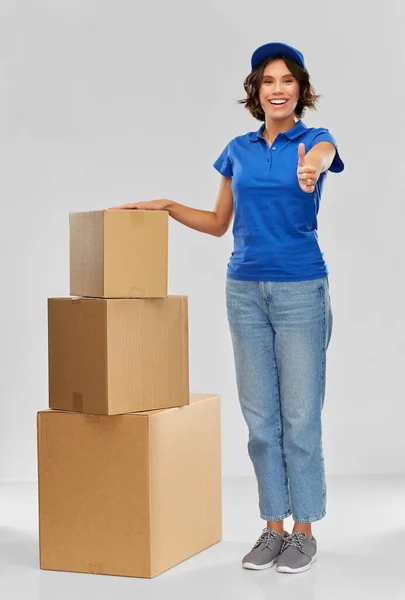 Menina de entrega feliz com caixas de encomendas em azul — Fotografia de Stock