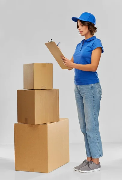 Chica entrega feliz con cajas y portapapeles —  Fotos de Stock