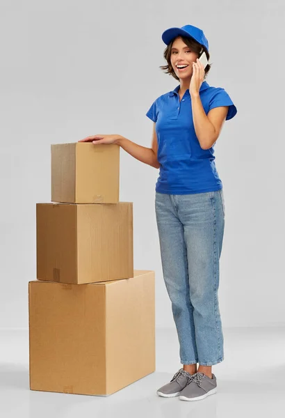 Consegna donna con scatole chiamando su smartphone — Foto Stock