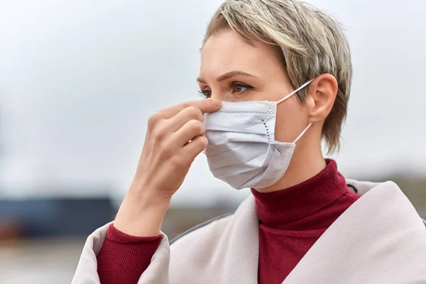 Young woman wearing protective medical mask — Stock Photo, Image