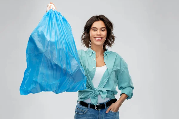 플라스틱 쓰레기통을 쓰레기로 들고 있는 미소짓는 여성 — 스톡 사진