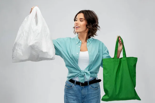 Plastik ve yeniden kullanılabilir alışveriş çantası olan kadın. — Stok fotoğraf
