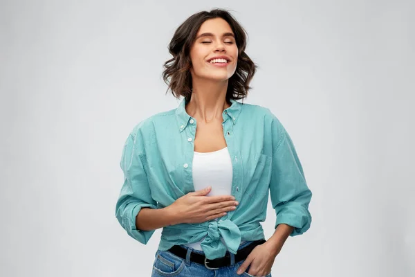 Happy full young woman touching her tummy — Stock Photo, Image