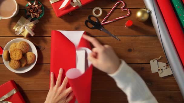 Manos envolviendo el regalo de Navidad en papel en casa — Vídeos de Stock