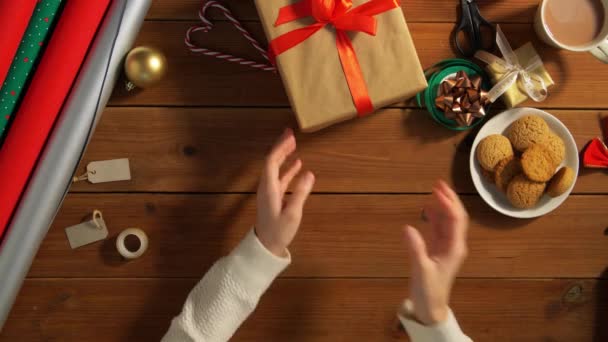 Руки складання упакованих різдвяних подарунків на столі — стокове відео
