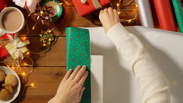 Manos envolviendo el regalo de Navidad en papel en casa — Vídeos de Stock