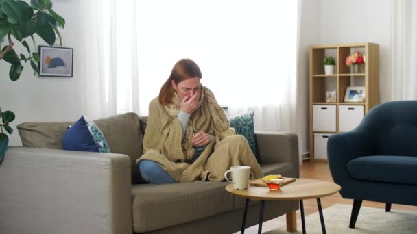 Szomorú, beteg fiatal nő forró teát iszik otthon — Stock videók