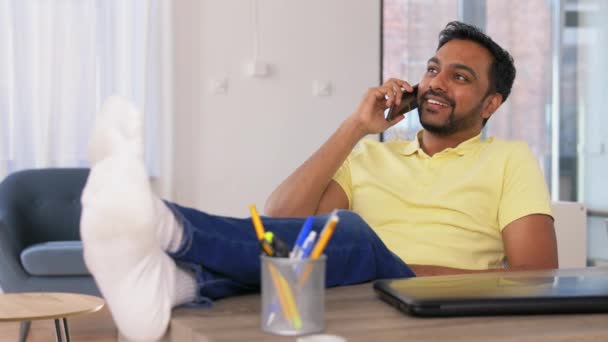 Щасливий чоловік телефонує на смартфон в домашньому офісі — стокове відео