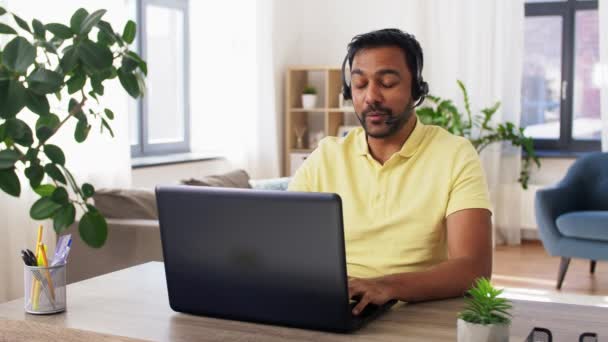 印度男子与耳机和笔记本电脑在家里工作 — 图库视频影像