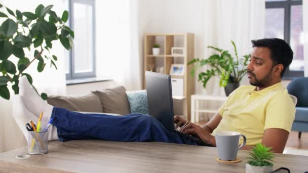 Уставший мужчина с ноутбуком, работающий в домашнем офисе — стоковое видео