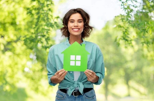Femme heureuse avec maison verte sur fond naturel — Photo