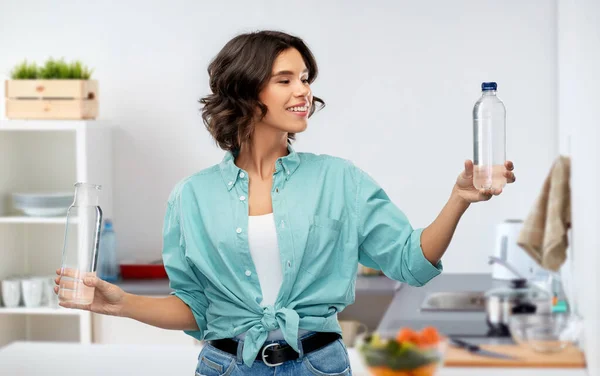 Sonriente joven mujer comparando botellas de agua — Foto de Stock