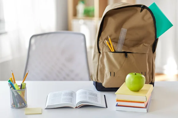 Könyvek, alma és iskolai kellékek az asztalon otthon — Stock Fotó
